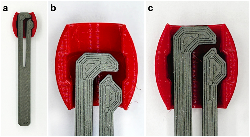 Drei Bilder (a, b, c) zeigen die Funktion der Sicherung der Spielsteine. Ein Stift mit einem Schlitz in der Mitte und Nase an der Seite steckt in einem roten Spielstein, der im senkrechten Schnitt gezeigt wird.