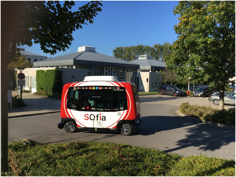 Ein kastenförmiger Kleinbus in rot-weißem Design mit der Aufschrift „SOfia“ biegt auf das Gelände des LWL-Berufsbildungswerkes Soest ein.